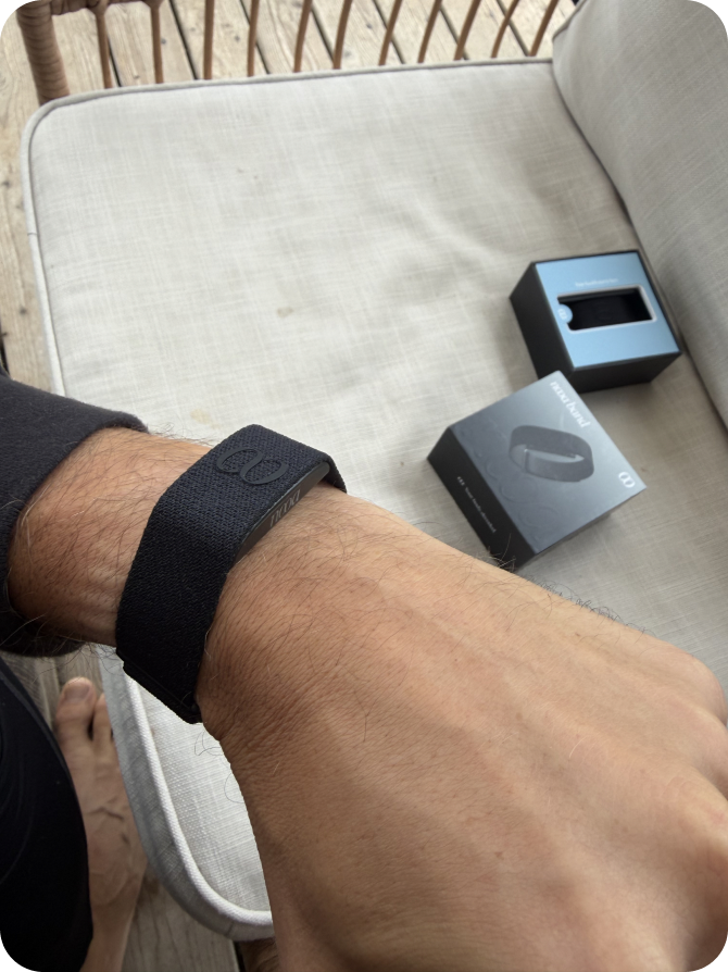 A NOOA Band worn on the wrist, with its packaging beside it