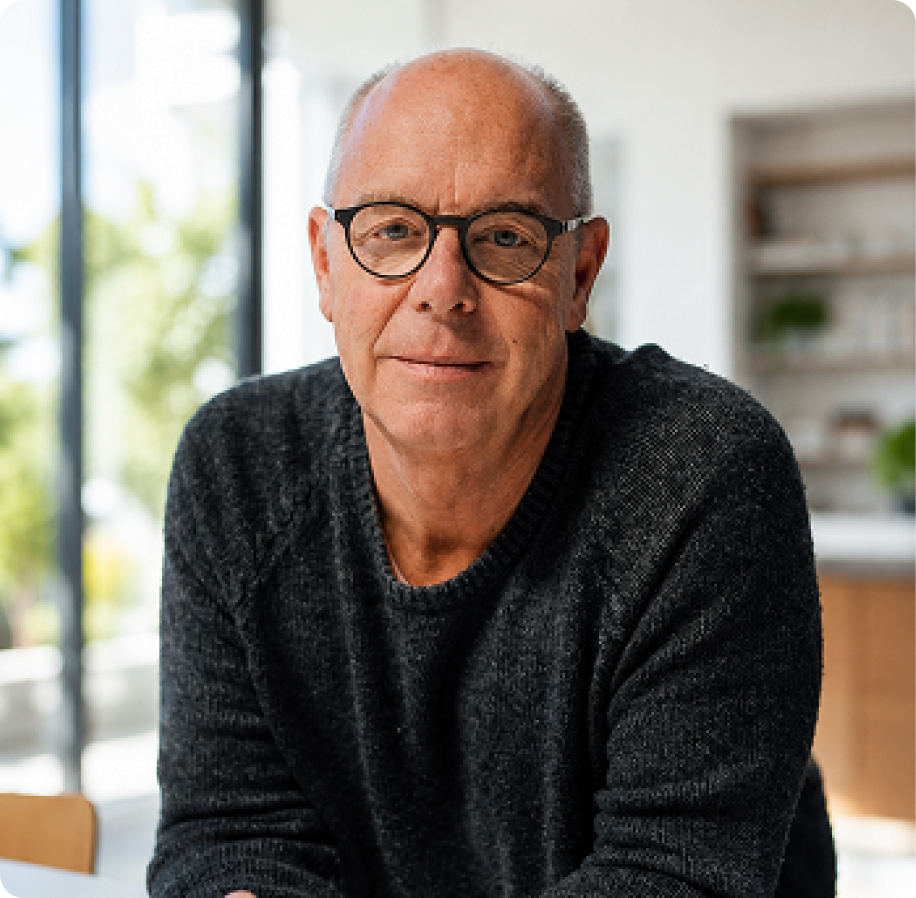 Man in his sixties sitting at a table in a bright room